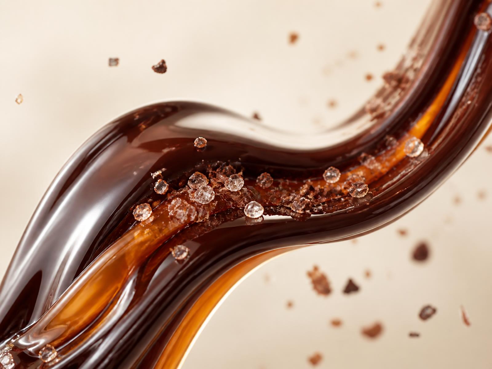 Macro view of flowing chocolate and caramel with crystalline ingredient texture